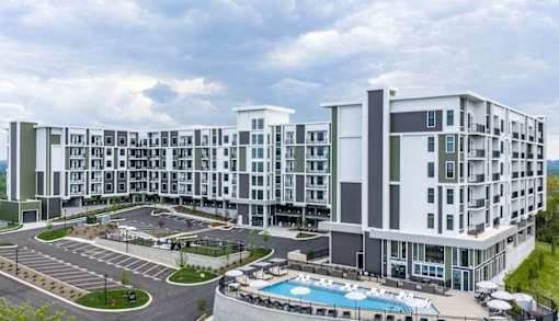 A large white building with a pool in front.