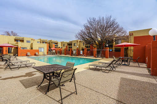 A pool area with a table and chairs.