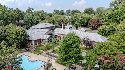 A large house with a pool surrounded by trees.