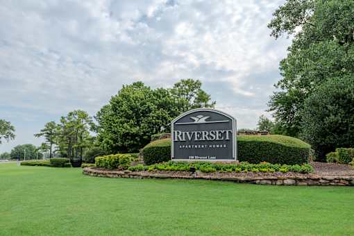 A sign for Riverset Apartment Homes sits in front of a well-manicured lawn.