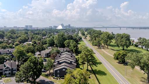 A residential area with houses and a bridge in the background.