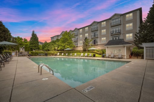 a swimming pool with an apartment building in the background