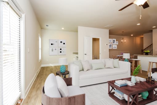 a living room filled with furniture and a ceiling fan