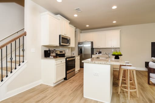 a kitchen with white cabinets and stainless steel appliances