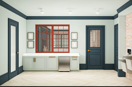 A kitchen with a red window and a trash bin.