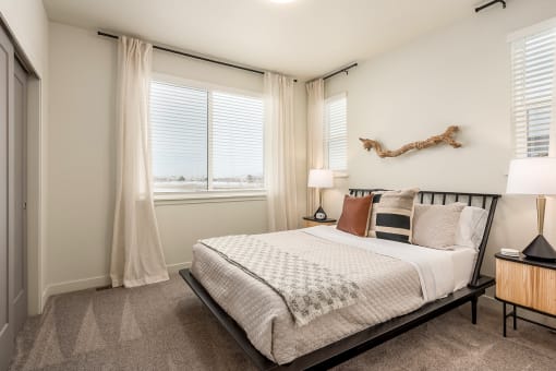 a bedroom with a bed and two windows