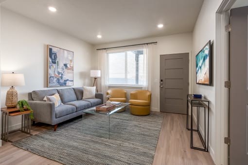 a living room with a couch and a coffee table in front of a window