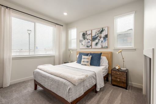 a bedroom with a bed and two windows