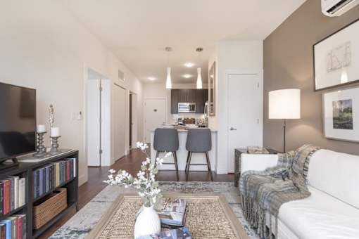 Furnished living room with a couch, coffee table, tv, and view of kitchen