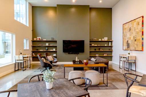 A living room with a grey table and a television on the wall.