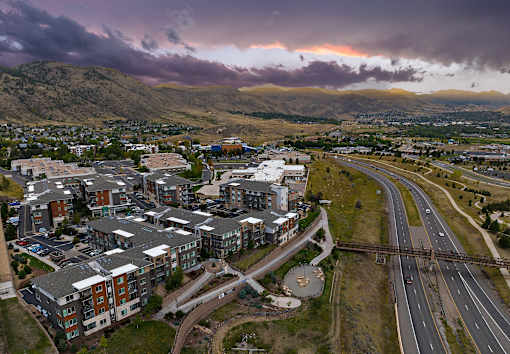 A large apartment complex is located next to a busy highway.