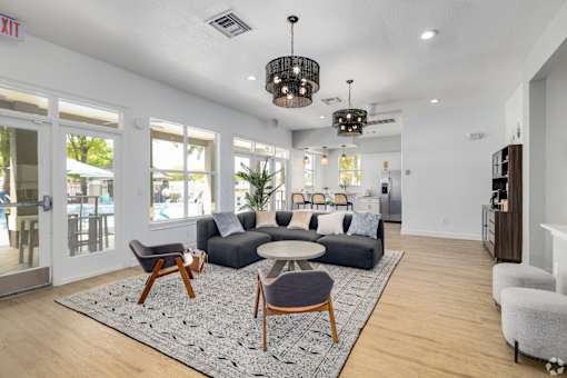 Clubhouse lounge with modern seating and chandeliers at Fusion Apartments, Orlando, Florida