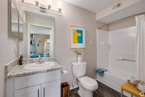 Modern bathroom with white vanity and granite countertop at Fusion Apartments, Orlando, FL