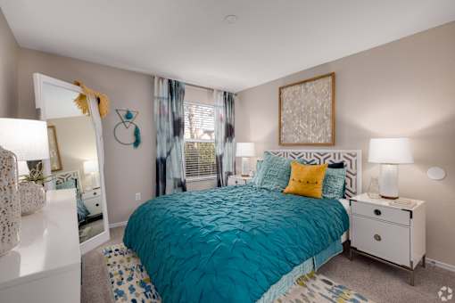 Bedroom with teal bedding and white furniture at Fusion Apartments, Orlando, 32818