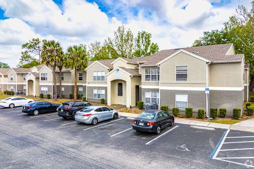 Exterior building with resident parking lot at Fusion Apartments, Orlando, Florida