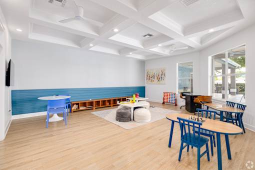 Playroom with activity tables and coffered ceiling at Fusion Apartments, Florida