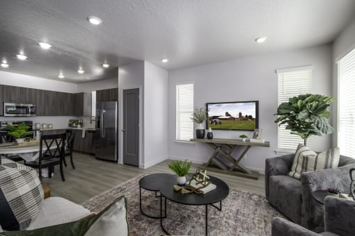 the living room and kitchen of a model home with a couch and a table