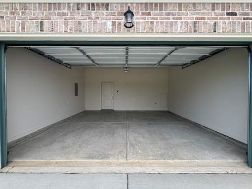 A garage with a brick wall above it and a door on the left.