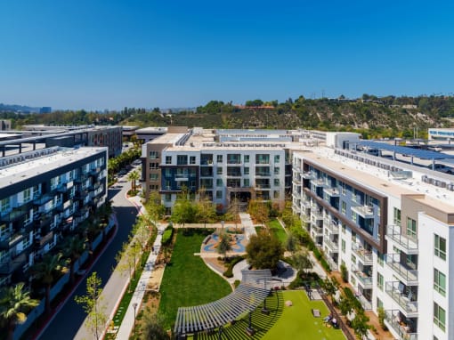 an aerial view of apartment buildings with a park in the middle at VORA LUX, San Diego, 92120