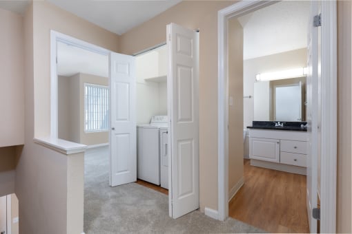a spacious living room and kitchen with white doors and white cabinets