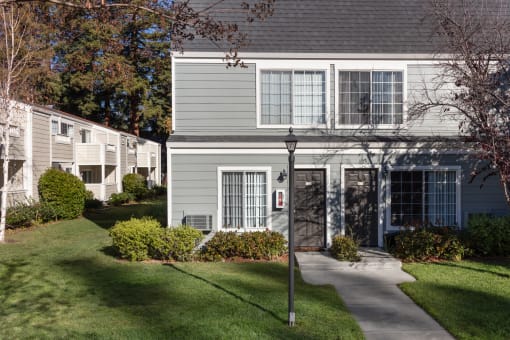 a house with gray siding and a light pole in front of it