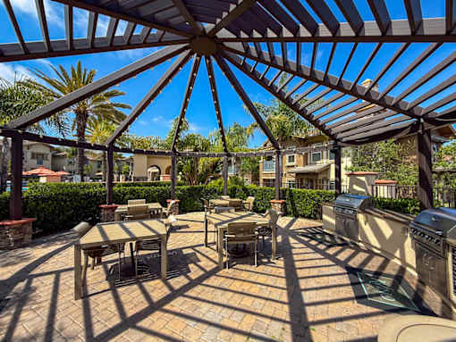 A patio with a table and chairs under a roof.