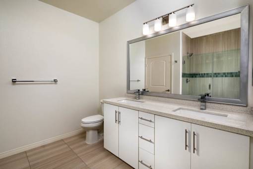A bathroom with a toilet, sink, and mirror.
