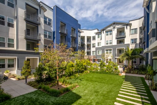 an image of an apartment complex with a grassy courtyard and trees at Citron, Anaheim, California