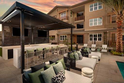 A patio with a fireplace and chairs is set up outside a building.