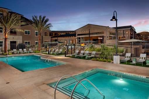 A swimming pool surrounded by palm trees and lounge chairs.