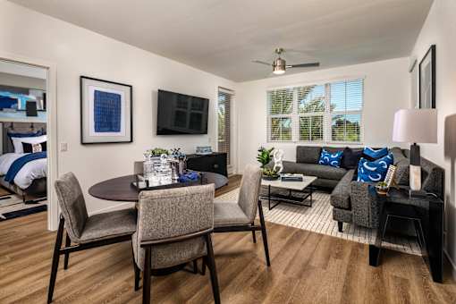 A modern living room with a dining table and chairs.
