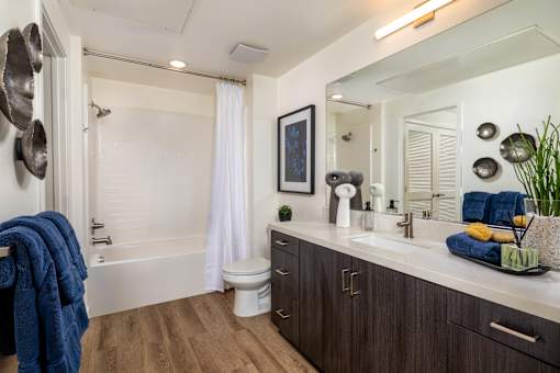 A bathroom with a white tub, sink, and toilet.