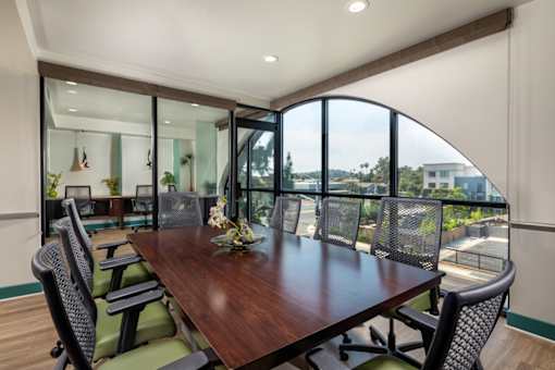 A conference room with a long table and chairs.