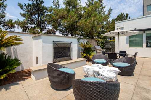 A patio with a fireplace and chairs.