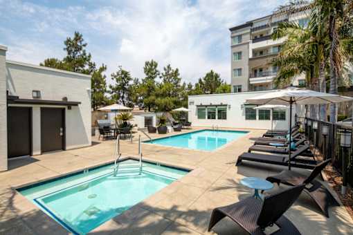 A pool with a ladder and a table with chairs.