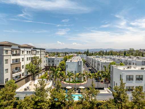 A view of apartment buildings with a pool in the foreground.