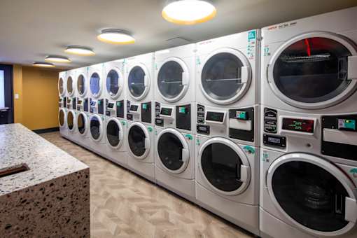 A row of industrial washing machines are lined up in a room.