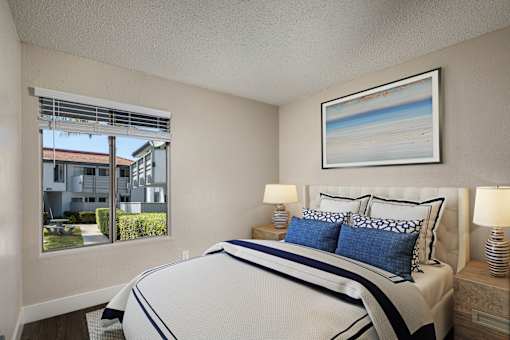 A bedroom with a large bed and a painting on the wall.