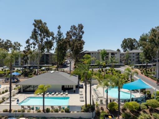an aerial view of two pools and trees