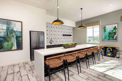 A modern kitchen with a white island and brown chairs at San Carlo Townhomes Apartments, Highland, CA, 92346