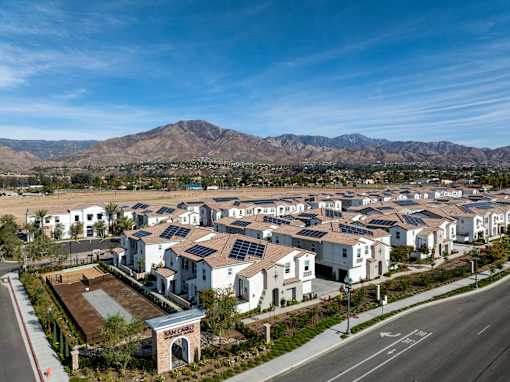 A residential area with houses and a mountain in the background at San Carlo Townhomes Apartments, California, 92346