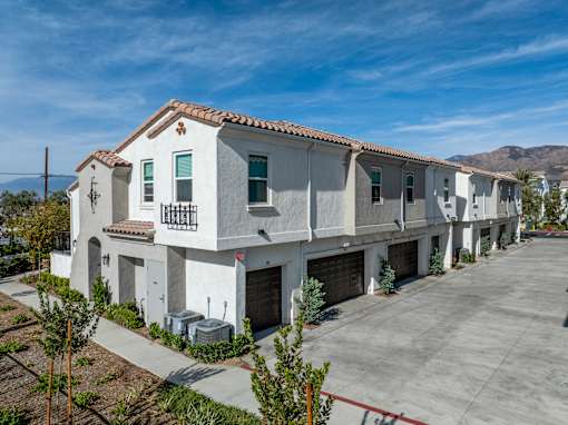 A row of houses with a mountain in the background at San Carlo Townhomes Apartments, Highland