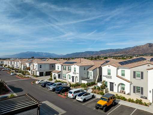 A row of houses with cars parked in front of them at San Carlo Townhomes Apartments, Highland