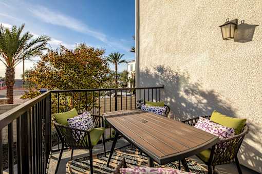 A table with chairs and a tablecloth on a balcony at San Carlo Townhomes Apartments, California