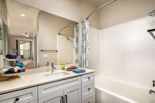 A bathroom with a white tub, sink, and shower at San Carlo Townhomes Apartments, Highland, CA