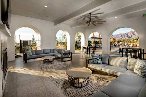 A living room with a grey sofa and a round table. at San Carlo Townhomes Apartments, Highland, CA, 92346