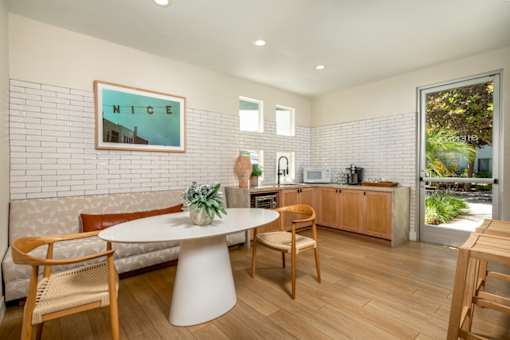 A dining area with a white table and chairs.