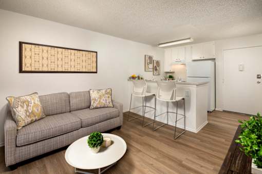 A living room with a grey couch and a white coffee table.