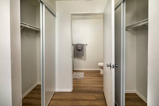A small, white bathroom with a toilet and a towel rack.
