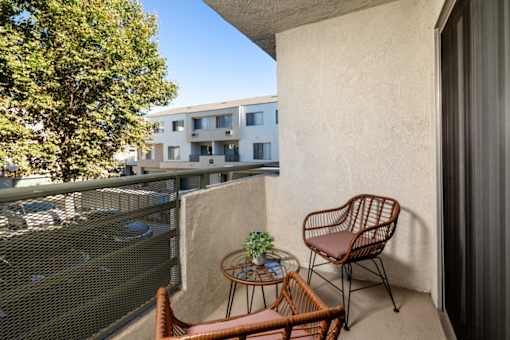 A balcony with a chair and table.